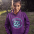 Featuring a stunning graphic of a majestic snowy owl in flight, set against the glowing northern lights, this hoodie embodies the freedom and grace of the province’s untamed wilderness.